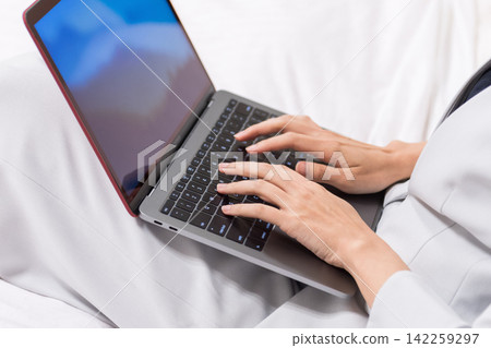 一位女士正在使用筆記型電腦。商務、個人電腦、數位轉型、工作、搜尋、部落格、鍵盤、輸入、電子郵件、社群媒體。 142259297