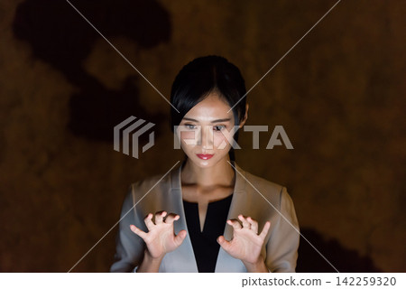 A woman operating a screen in mid-air in the dark. VR, virtual, sci-fi, touch, HUD, UX, tech, hologram A woman operating a screen in mid-air in the dark. VR, virtual, sci-fi, touch, HUD, UX, tech, hologram 142259320