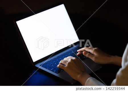一名女子在黑暗的房間裡使用電腦。個人電腦、黑暗、犯罪、犯罪預防、安全、風險、駭客、互聯網 一名女子在黑暗的房間裡使用電腦。個人電腦、黑暗、犯罪、犯罪預防、安全、風險、駭客、互聯網 142259344