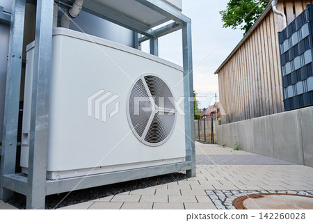 Outdoor heat pump unit installed beside residential building in city Outdoor heat pump unit installed beside residential building in city 142260028