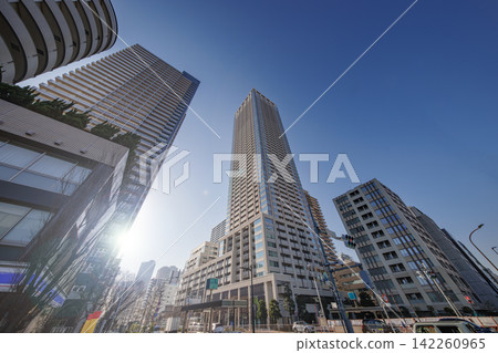 一棟超高層公寓大樓在藍天的襯托下格外醒目,沐浴在耀眼的陽光中。 一棟超高層公寓大樓在藍天的襯托下格外醒目,沐浴在耀眼的陽光中。 142260965