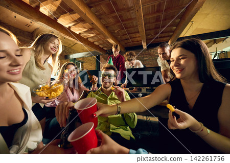 Office friends sharing snacks and colorful drinks during lively company party Office friends sharing snacks and colorful drinks during lively company party 142261756