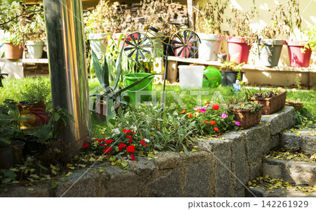 Rustic Austrian garden with potted plants and a stone wall highlights country charm with natural and crafted details. Rustic Austrian garden with potted plants and a stone wall highlights country charm with natural and crafted details. 142261929