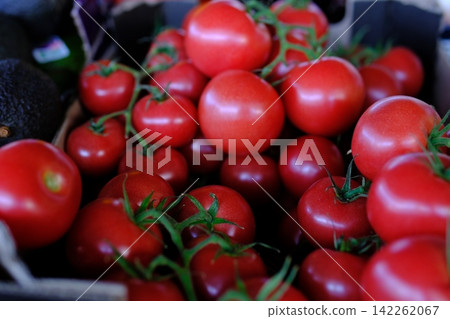 Fresh ripe tomatoes displayed at local farmers market, quality seasonal produce for grocery shopping, healthy cooking, farm harvest and natural everyday nutrition Fresh ripe tomatoes displayed at local farmers market, quality seasonal produce for grocery shopping, healthy cooking, farm harvest and natural everyday nutrition 142262067