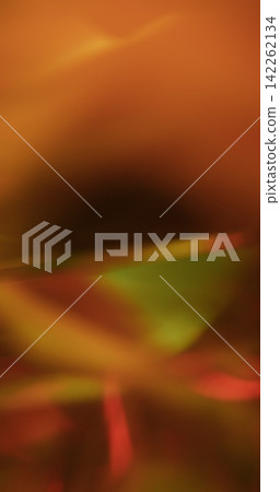 Defocused shiny crystal. Illuminated abstraction. Orange green pink colorful glass angle optical gleam on luminous warm glisten background. Defocused shiny crystal. Illuminated abstraction. Orange green pink colorful glass angle optical gleam on luminous warm glisten background. 142262134