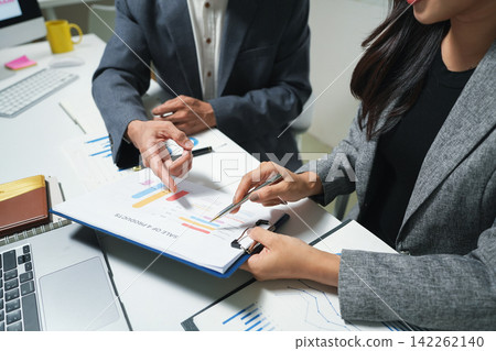 Business Team Reviewing Financial Charts in Office Business Team Reviewing Financial Charts in Office 142262140
