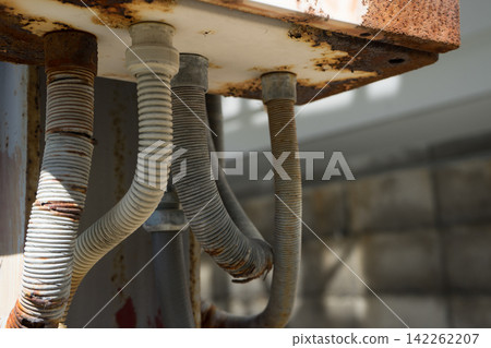 A pipe extending downwards from a rusty box. A pipe extending downwards from a rusty box. 142262207