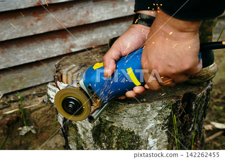 Cutting metal pipe with an angle grinder close-up Cutting metal pipe with an angle grinder close-up 142262455