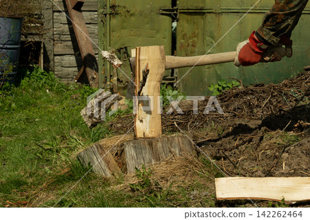 A man chops wood withan axe. Preparing fuelfor the winter A man chops wood withan axe. Preparing fuelfor the winter 142262464