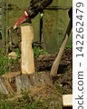 A man chops wood withan axe. Preparing fuelfor the winter 142262479