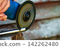 Cutting metal pipe with an angle grinder close-up 142262480