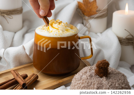 Seasonal drink cacao coffee with whipped cream and cinnamon sticks Thanksgiving and Hello Fall Halloween concept. Celebrating autumn holidays at cozy home on the windowsill atmosphere Autumn leaves Seasonal drink cacao coffee with whipped cream and cinnamon sticks Thanksgiving and Hello Fall Halloween concept. Celebrating autumn holidays at cozy home on the windowsill atmosphere Autumn leaves 142262936