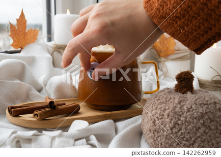 Autumn hygge Orange Cup of warm coffee autumn leaves on table against raindrops are running down the glass in window. Cozy fall still life footage burning candles. Thanksgiving and Halloween holiday Autumn hygge Orange Cup of warm coffee autumn leaves on table against raindrops are running down the glass in window. Cozy fall still life footage burning candles. Thanksgiving and Halloween holiday 142262959