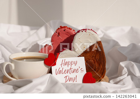 HAPPY VALENTINE'S DAY phrase lettering paper greeting card Morning breakfast in bed in wooden tray Present gift idea Holiday celebration Heart shaped croissants. Puff pastry new trendy sweet dessert HAPPY VALENTINE'S DAY phrase lettering paper greeting card Morning breakfast in bed in wooden tray Present gift idea Holiday celebration Heart shaped croissants. Puff pastry new trendy sweet dessert 142263041