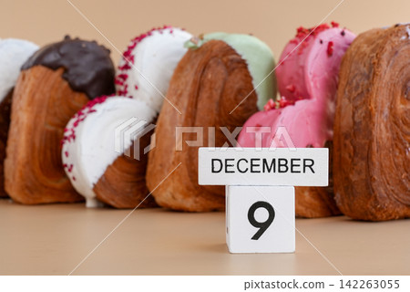 Pastry day 9 December wooden calendar cubes wishes greeting holiday card Heartshaped pastry croissant treat topped with colorful frosting galore. Food experimentation viral dessert baking trend Pastry day 9 December wooden calendar cubes wishes greeting holiday card Heartshaped pastry croissant treat topped with colorful frosting galore. Food experimentation viral dessert baking trend 142263055