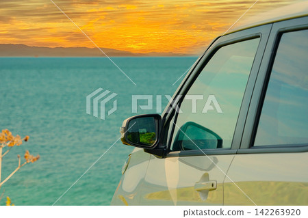 A white Japanese car overlooking the sea in the autumn evening. A white Japanese car overlooking the sea in the autumn evening. 142263920