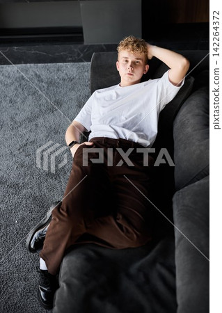 Youthful individual reclines peacefully on comfortable sofa Youthful individual reclines peacefully on comfortable sofa 142264372