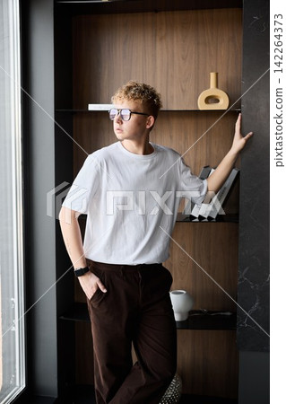 Youthful individual relaxes with sketchbook in bright space Youthful individual relaxes with sketchbook in bright space 142264373