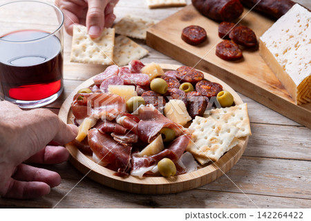People sharing Spanish charcuterie board with ham, chorizo and cheese People sharing Spanish charcuterie board with ham, chorizo and cheese 142264422