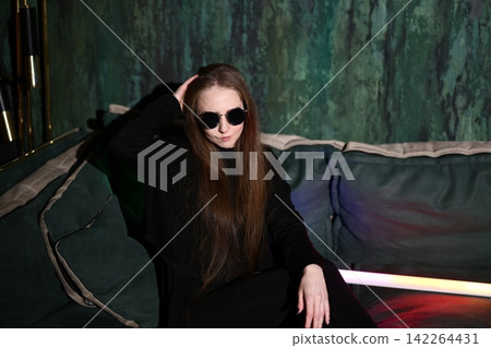 Confident female model in glamorous evening attire under neon lights Confident female model in glamorous evening attire under neon lights 142264431