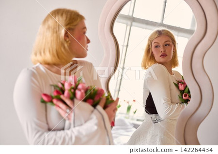 Caucasian bride in mirror expresses calm happiness after vows Caucasian bride in mirror expresses calm happiness after vows 142264434