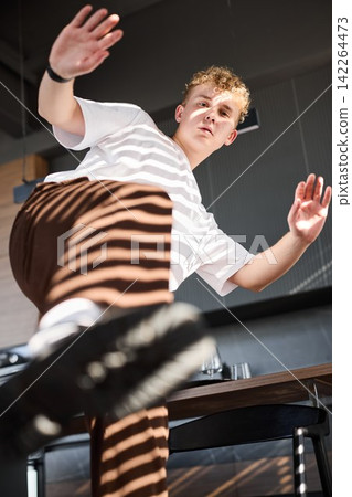 Man wearing casual white clothes crosses table confidently Man wearing casual white clothes crosses table confidently 142264473