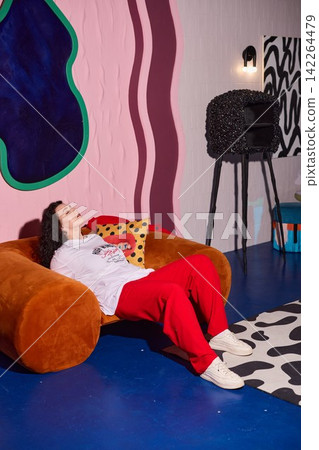Lady experiences serenity seated comfortably on upscale studio sofa Lady experiences serenity seated comfortably on upscale studio sofa 142264479
