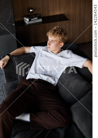 Relaxed male resting. Young man relaxes at home after work hours Relaxed male resting. Young man relaxes at home after work hours 142264543