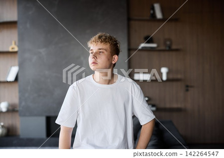 Youthful thoughtful portrait. Man gazes toward bright window Youthful thoughtful portrait. Man gazes toward bright window 142264547