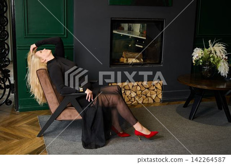 Refined female figure lounging in chic black attire with vibrant accents Refined female figure lounging in chic black attire with vibrant accents 142264587