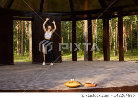 Creative performer mixes classic moves with modern clothing outdoors Creative performer mixes classic moves with modern clothing outdoors 142264680
