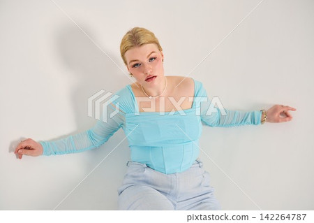 Woman in denim considers ladder and draped cloth thoughtfully in studio Woman in denim considers ladder and draped cloth thoughtfully in studio 142264787
