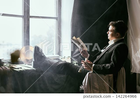 An older Asian man practices meditation with prayer beads by window An older Asian man practices meditation with prayer beads by window 142264966