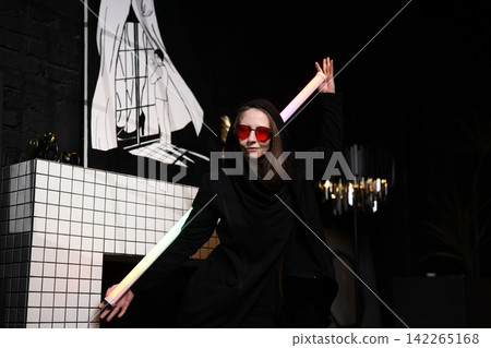 Caucasian woman wearing red glasses dancing with vibrant neon lights Caucasian woman wearing red glasses dancing with vibrant neon lights 142265168