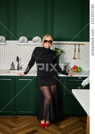 Fashionable woman poses confidently amidst modern kitchen decor elements Fashionable woman poses confidently amidst modern kitchen decor elements 142265190