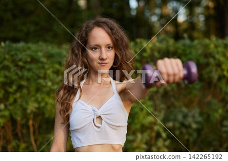 White woman softfocus strength portrait with dumbbell White woman softfocus strength portrait with dumbbell 142265192