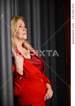 Thoughtful woman in vibrant attire during introspective interior moment 142265343