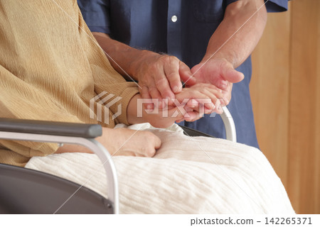 一位中年丈夫安慰坐輪椅的妻子。 一位中年丈夫安慰坐輪椅的妻子。 142265371