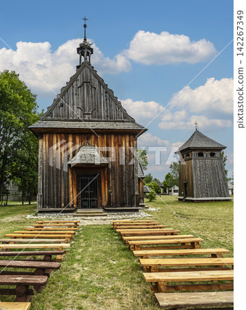 Historic Wooden Church With Outdoor Benches And Separate Bell Tower Under Blue Summer Sky Historic Wooden Church With Outdoor Benches And Separate Bell Tower Under Blue Summer Sky 142267349