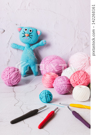 Balls of yarn and crochet hooks, a knitted toy on the table vertical view Balls of yarn and crochet hooks, a knitted toy on the table vertical view 142268161