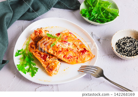 Tomato cheese omelette with herbs on a plate on the table 142268169