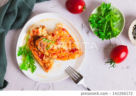 Airy egg omelette with tomatoes on a plate on the table top view Airy egg omelette with tomatoes on a plate on the table top view 142268172
