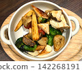 A round of roasted vegetables, served in a white porcelain bowl with chimney ears 142268191