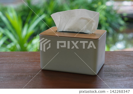side view tissue white and brown box made of plastic with a wooden lid, on a wooden floor, blur nature background, clean, comfortable, copy space 142268347