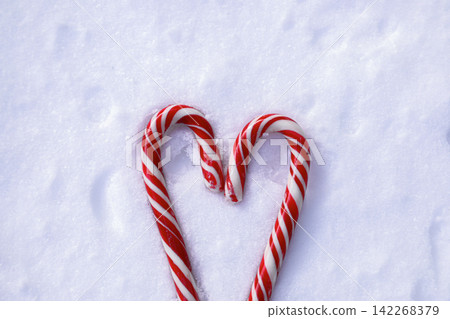 Candy canes in snow shaped like a heart Candy canes in snow shaped like a heart 142268379