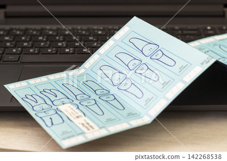 Macro Close-Up of Dental Implant Tooth Numbering Guide Card Resting on Laptop Keyboard Macro Close-Up of Dental Implant Tooth Numbering Guide Card Resting on Laptop Keyboard 142268538