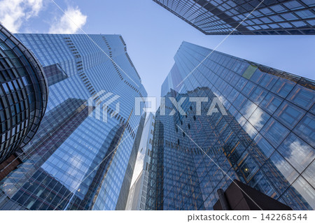 Glass skyscrapers reflecting the blue sky and clouds in city center 142268544