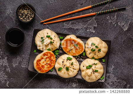 Delicious buns served on a plate with sauces and toppings 142268880