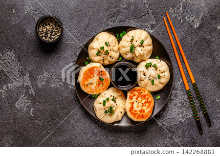 Delicious buns served on a plate with sauces and toppings Delicious buns served on a plate with sauces and toppings 142268881