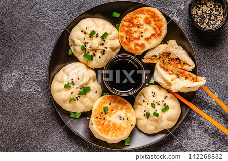 Delicious buns served on a plate with sauces and toppings Delicious buns served on a plate with sauces and toppings 142268882